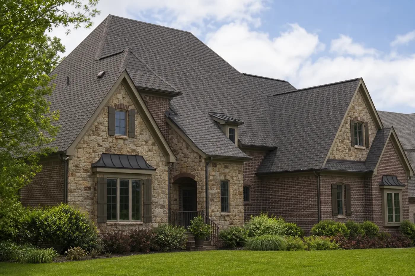 Roof-dominant upscale Indian Trail NC brick-and-stone home with a coherent architectural shingle roof