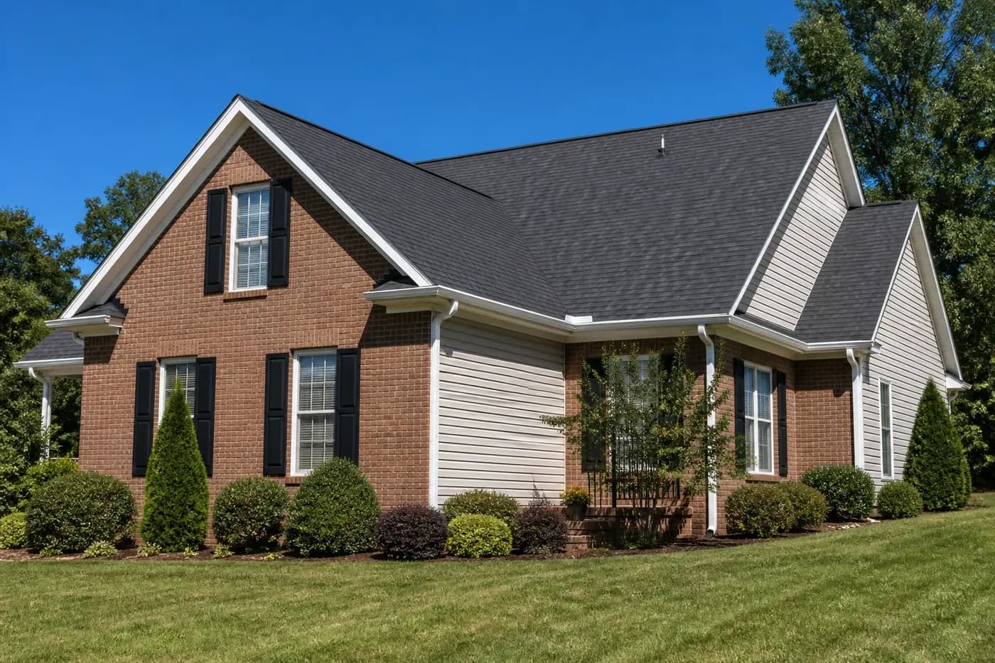 Roof-dominant upscale Indian Trail NC brick home with a clean architectural shingle roof