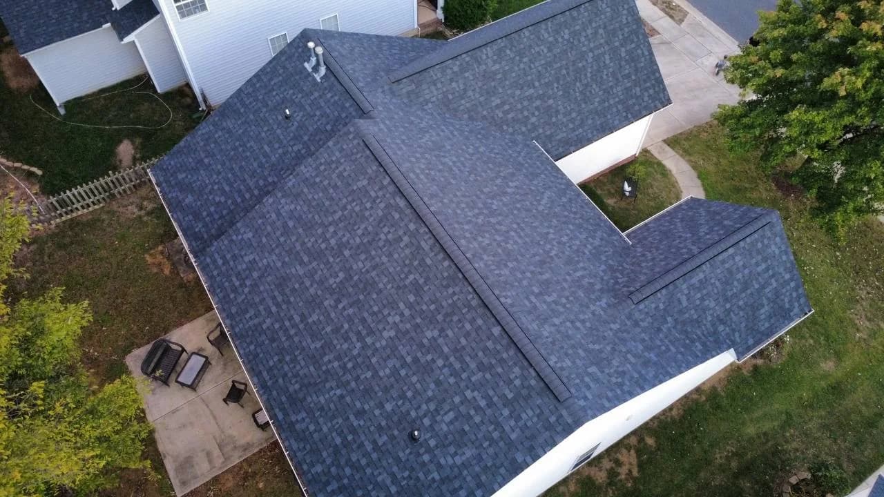 Overhead drone photo showing architectural shingles on a white home with multiple roof planes