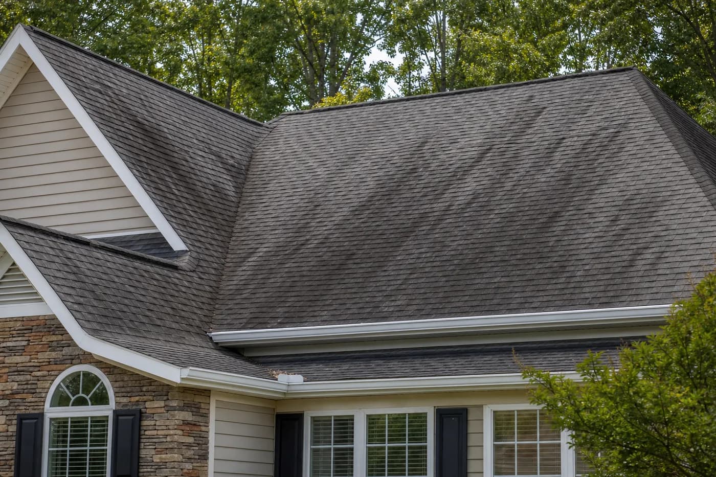 Charlotte NC asphalt shingle roof with dark algae streaks under mature trees