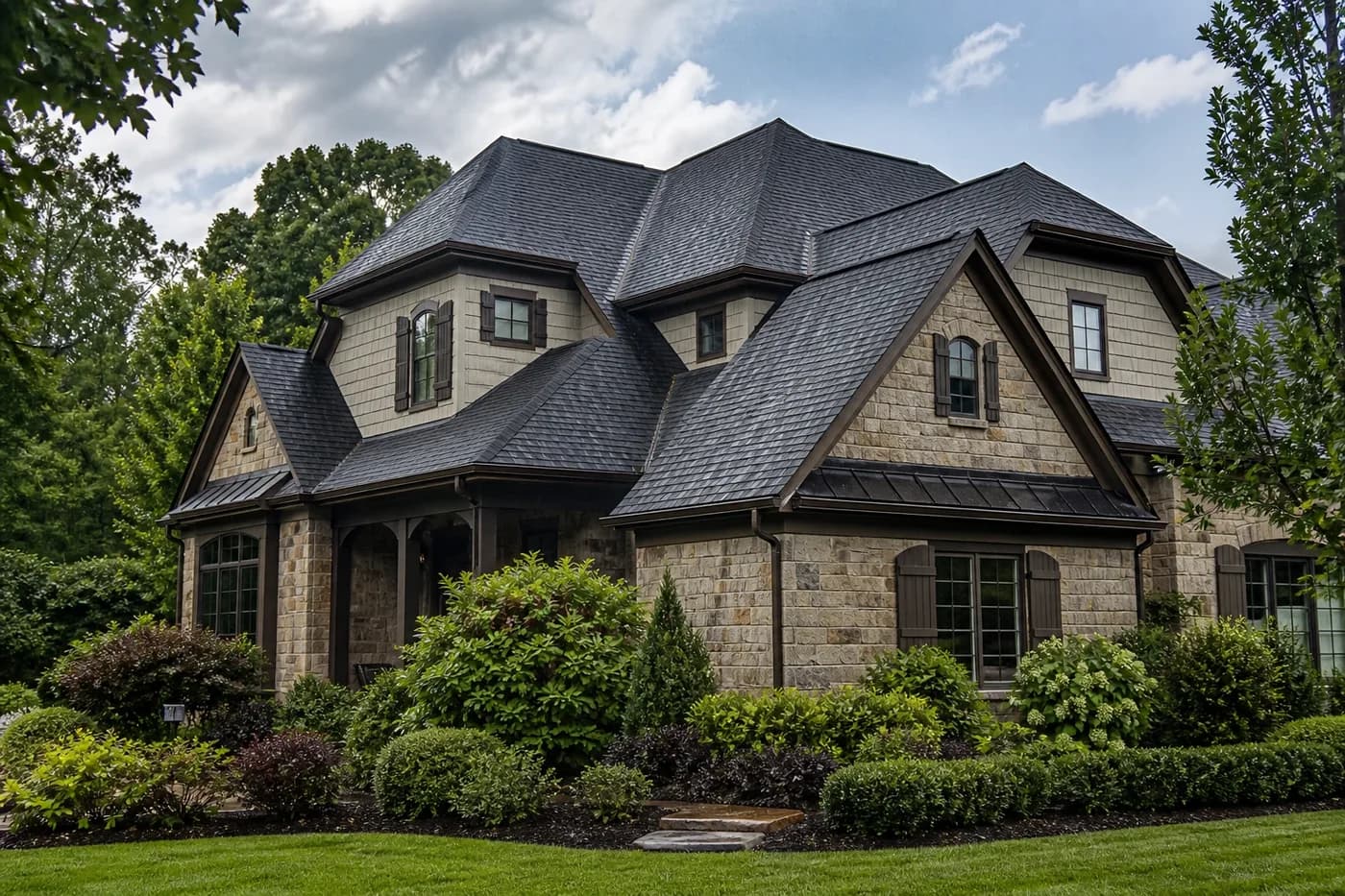 Roof-dominant upscale Indian Trail NC stone home with a coherent charcoal architectural shingle roof after rain
