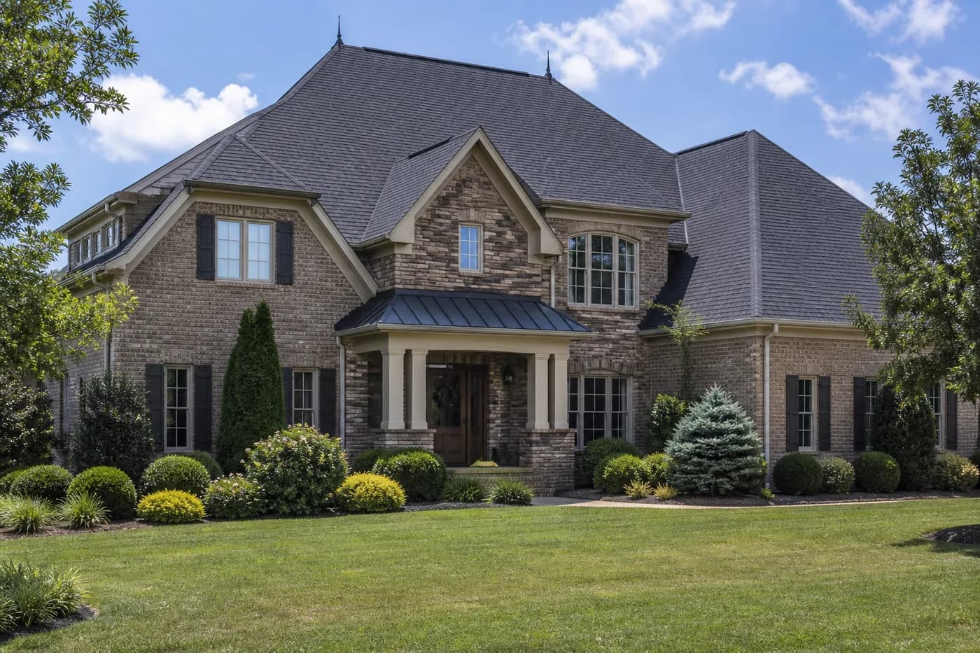 Roof-dominant upscale Indian Trail NC brick-and-stone home with a coherent architectural shingle roof