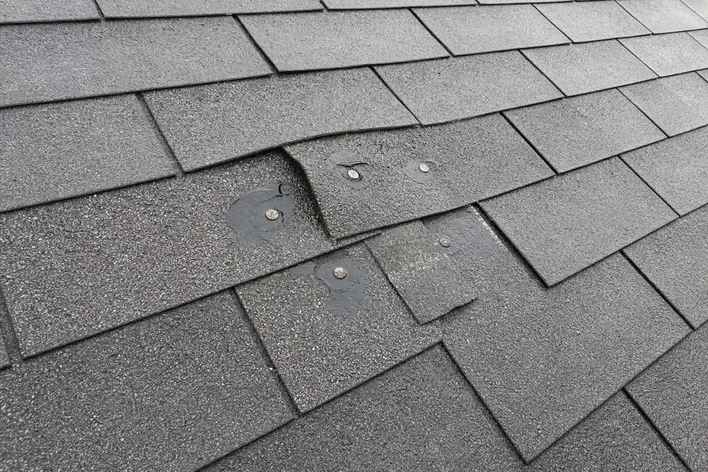Indian Trail NC asphalt shingle roof with old satellite dish mounting fasteners and sealant after rain