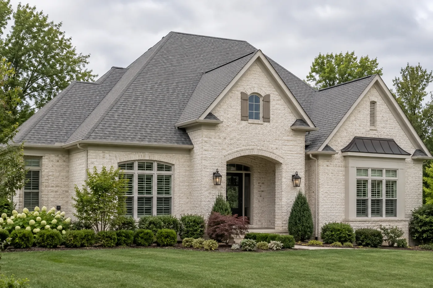 Cream brick home with a gray architectural-shingle roof and clean roof edges