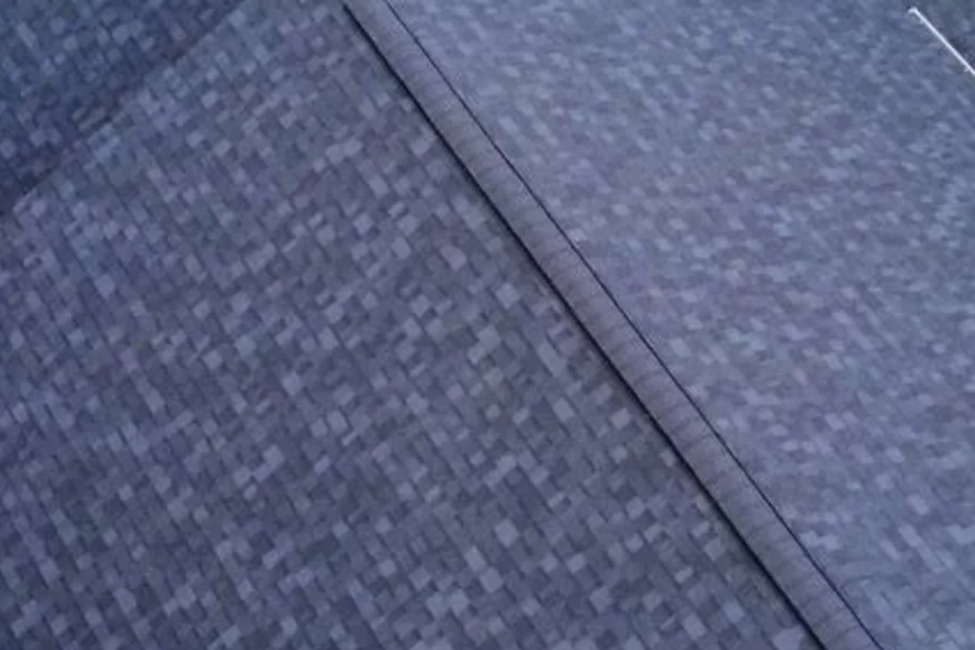 Close aerial view of a completed Kaliber architectural-shingle roof showing coherent shingle courses and a capped hip